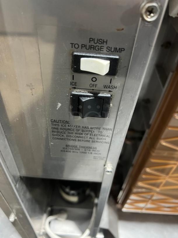 Ice-O-Matic Elevation Series ICE1006HA2 commercial ice machine controls, showing power switches and caution label.