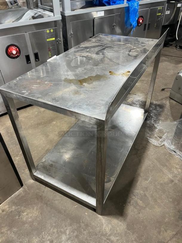 Commercial stainless steel food prep work table with one undershelf, used condition. Sturdy construction, signs of wear.