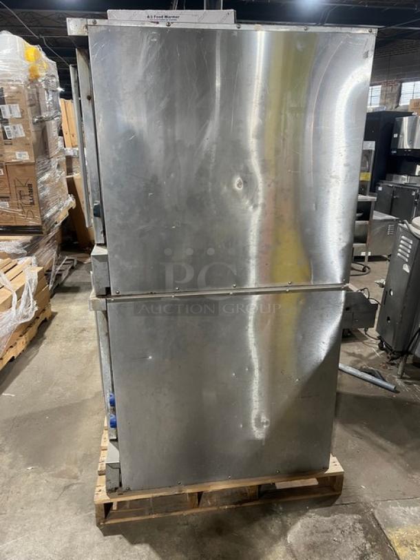 Imperial stainless steel double-stacked convection oven, natural gas-powered, on casters, with wired oven rack, dented surface.