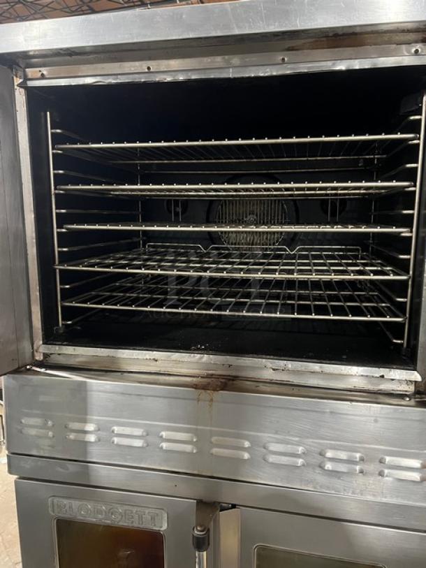 Blodgett stainless steel natural gas double-stacked convection oven with wired rack, on legs, visible wear.