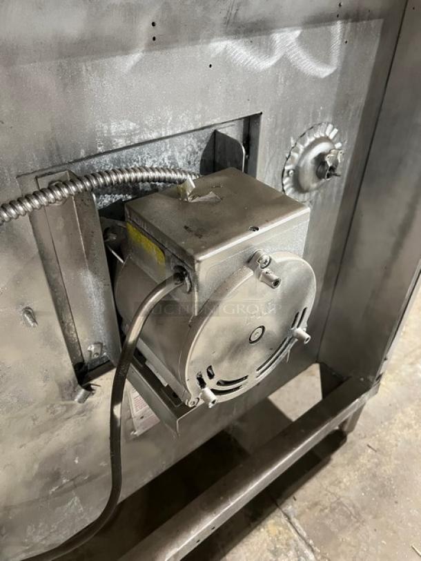 Blodgett commercial stainless steel natural gas convection oven, double-stacked, with wired oven rack on legs, rear view.