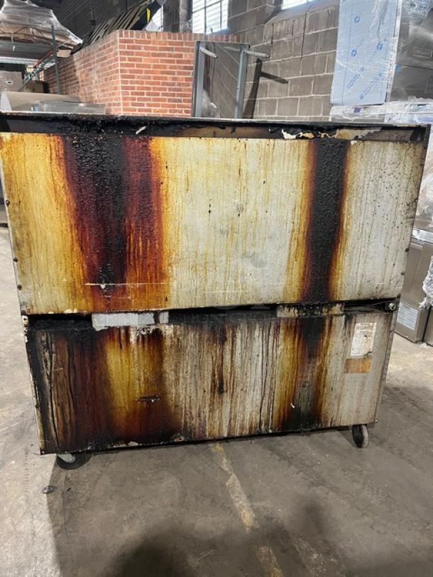 Southbend commercial stainless steel range/griddle/double oven in fair condition with rust and discoloration, on casters.