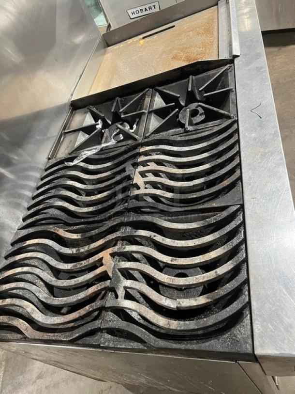 Southbend commercial stainless steel range with griddle, double oven combo, back/side splash, overhead salamander shelf, on casters.