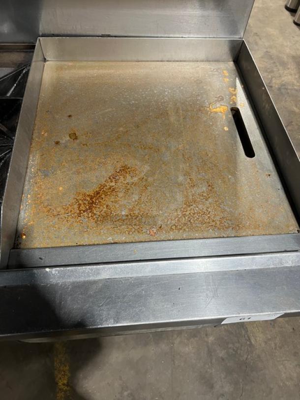 Southbend commercial stainless steel range and griddle combo with double oven, backsplash, salamander shelf, on casters. Some surface rust visible.