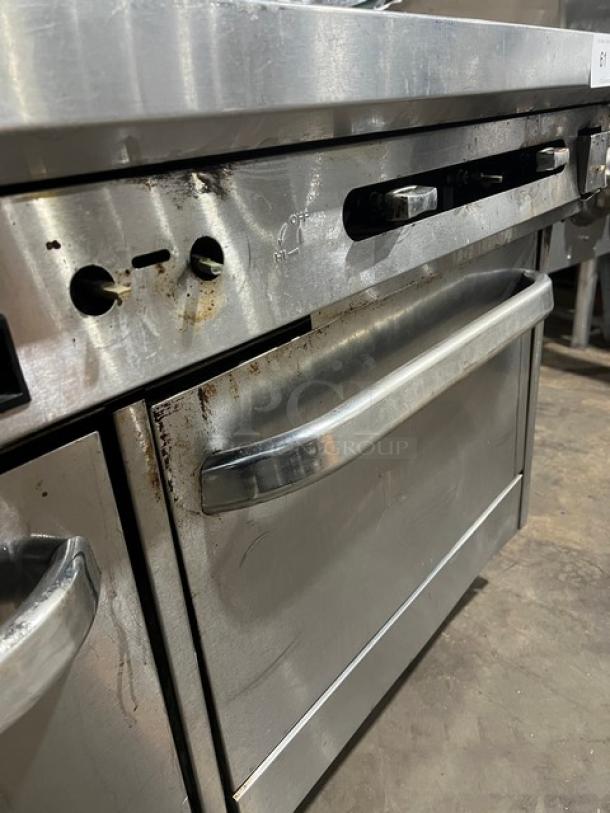 Southbend commercial stainless steel range/griddle/double oven combo with overhead salamander shelf, on casters. Moderate wear.