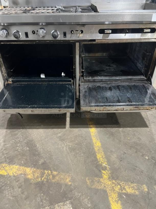 Southbend commercial stainless steel range with griddle and double oven, showing open ovens. Includes splash guards and overhead salamander shelf. Mounted on casters.