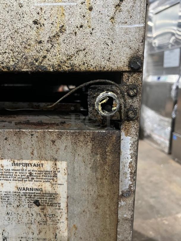 Southbend commercial stainless steel range/griddle combo showing rust and wear, with visible safety warning label.