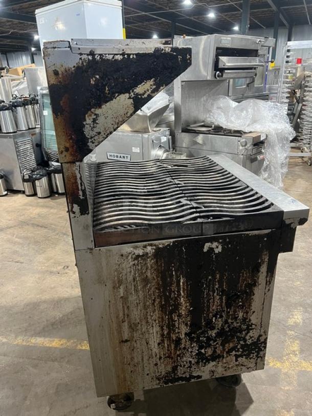 Southbend stainless steel 6-burner range/oven combo, natural gas, with backsplash, overhead salamander shelf, and casters.