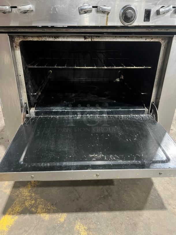 Southbend stainless steel 6-burner range/oven combo with wired rack, backsplash, overhead salamander shelf, and casters.