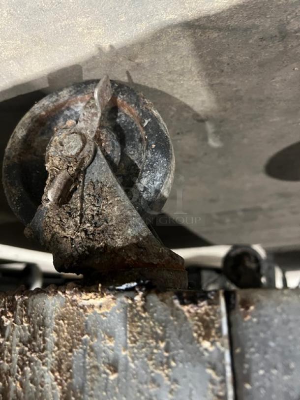 Southbend commercial stainless steel range/oven caster. Rusted condition, indicating wear.