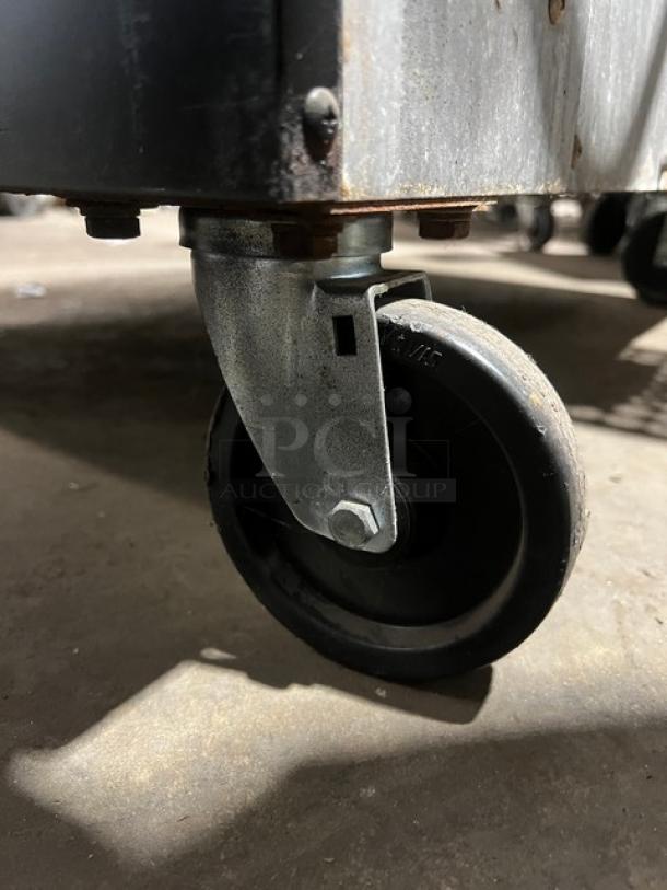 Southbend SilverStar Series commercial oven caster, showing attached wheel in used condition, supporting stainless steel body.