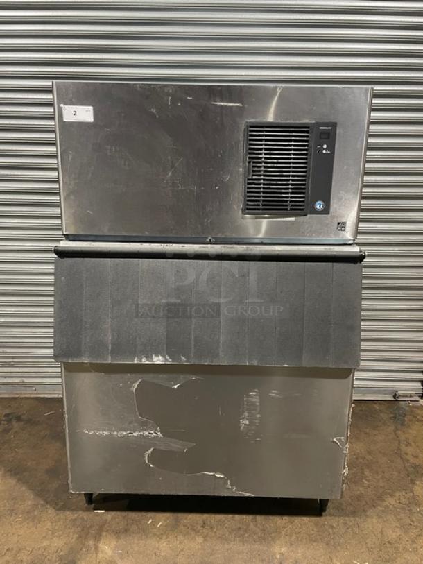 Hoshizaki IM-500SAA commercial ice maker, stainless steel, air-cooled, on legs, 115V, with ice scoop, visible signs of wear.