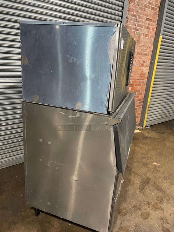 Hoshizaki IM-500SAA stainless steel ice maker/bin, electric-powered, air-cooled, on legs with visible wear. Includes ice scoop.