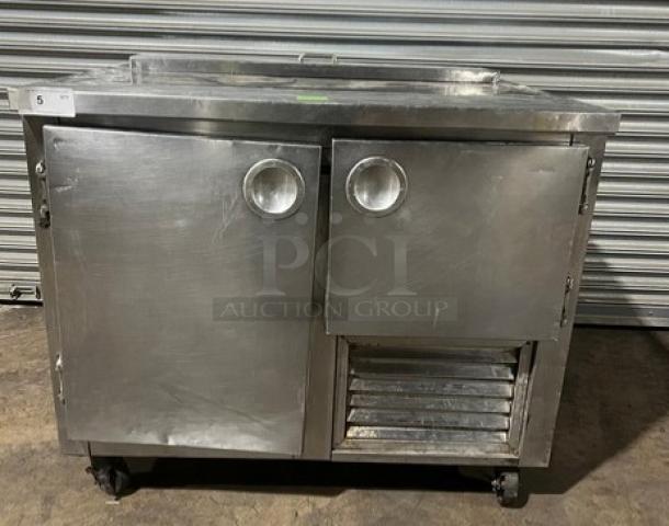 Commercial stainless steel refrigerated salad/sandwich prep table, 1-1/2 door, poly coated rack, on casters, in used condition.