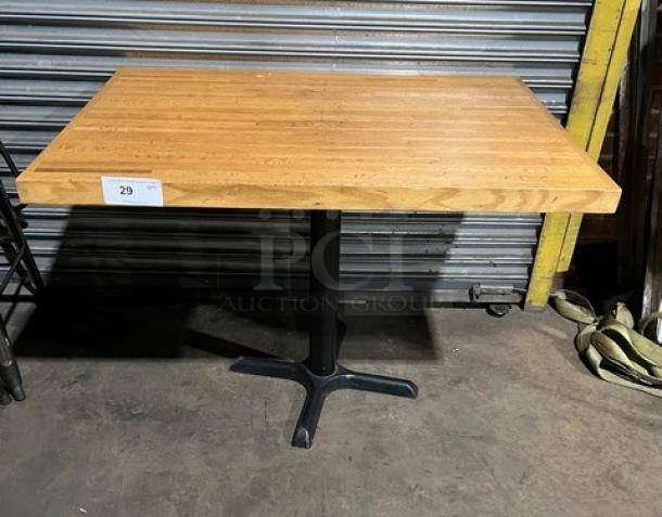 Commercial wooden rectangular tabletop with a pedestal base, in good condition. Auction label with number 29 attached.