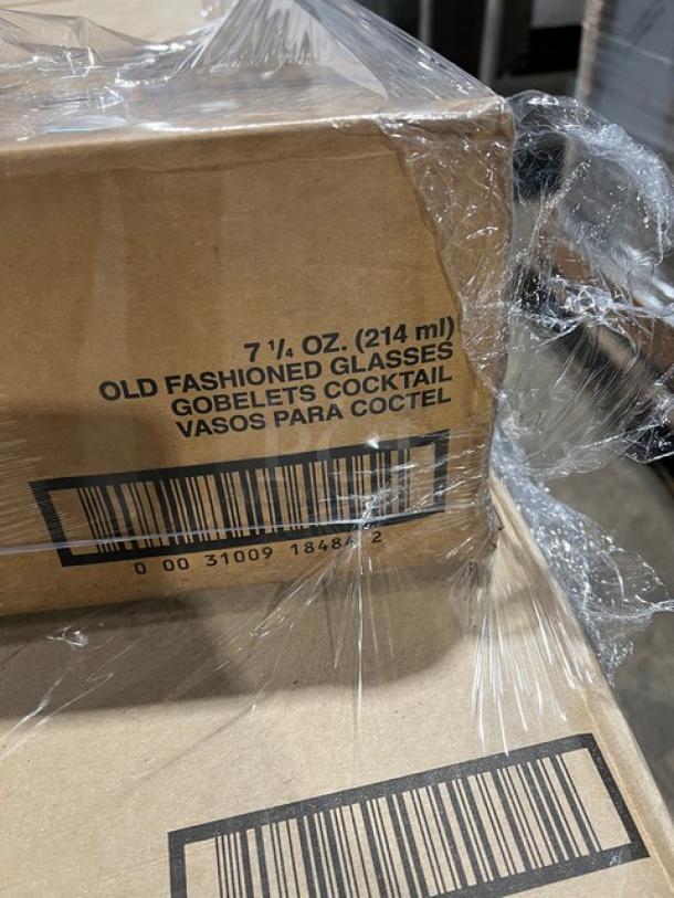 Mixed pallet of commercial glassware in original packaging, including Libbey martini, water, pilsner, hi-ball, and cooler glasses.