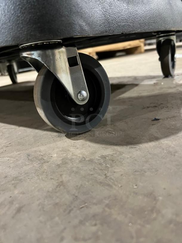 Carlisle black 3-tier utility cart, scratch-n-dent condition, close-up of caster wheel, sturdy, commercial grade.