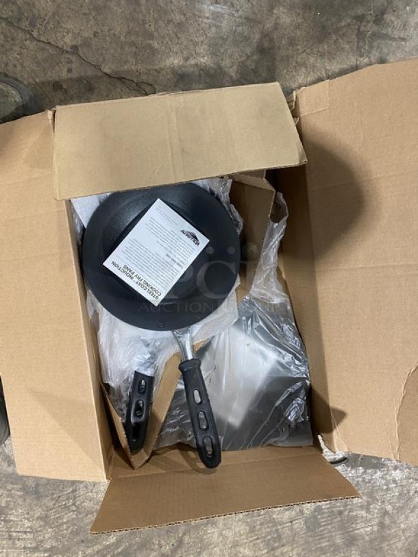 Brand new Vollrath 9-3/8" round fry pan, model 5923938, with SteelCoat-x3 non-stick coating and black silicone grip.