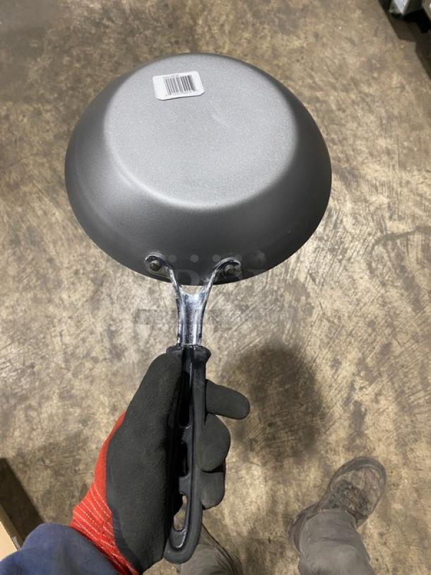 Brand new Vollrath 9-3/8" round fry pan, model 5923938, with SteelCoat-x3 non-stick coating and black silicone grip.