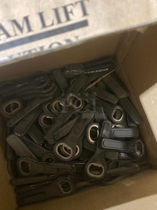 Box containing multiple black handheld bottle openers.