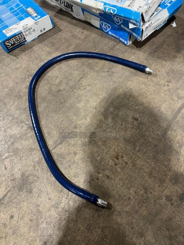 T&S Safe-T-Link 1/2"x48" water hose, model HW-2C-48, new condition, blue with metal fittings, on a warehouse floor.