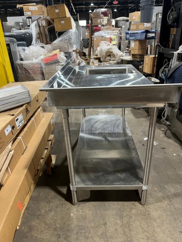Brand new Advance Tabco stainless steel worktop/prep table with right-side sink, back and left-side splash, undershelf, and legs.