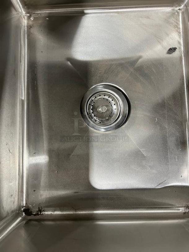 Advance Tabco stainless steel sink detail, new condition, with smooth finish and visible drain. Part of commercial prep table.