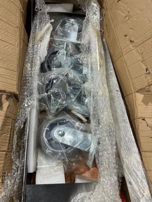Brand new commercial double convection oven stacking kit with casters, in packaging with bubble wrap, ready for assembly.
