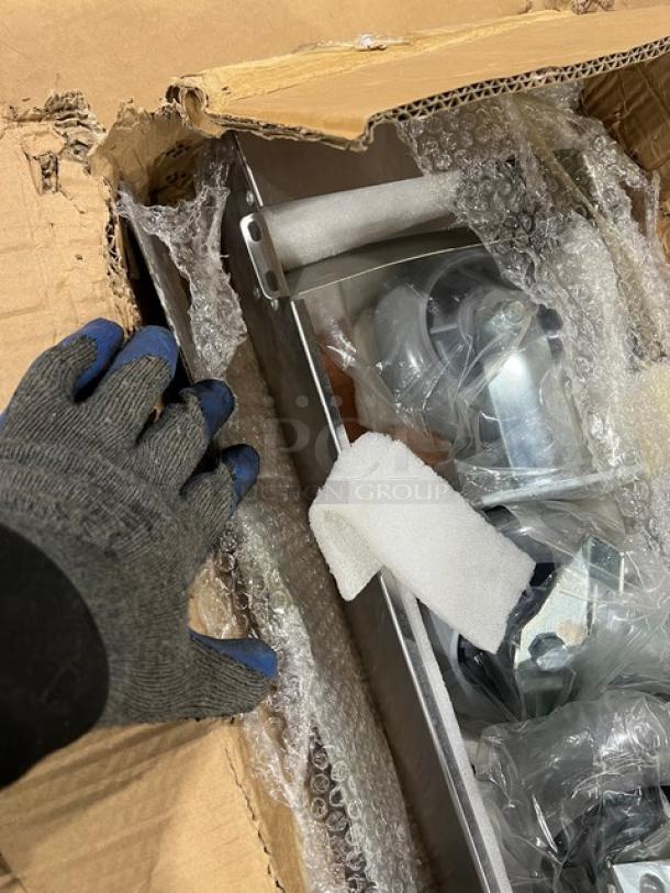 Brand new commercial double convection oven stacking kit with casters, partially unpacked in box with protective bubble wrap.