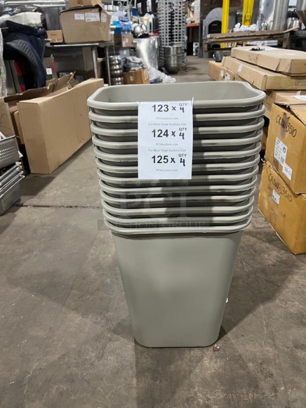 Brand new Rubbermaid Commercial beige medium trash cans stacked, with auction labels showing item quantities.