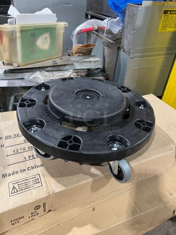 Brand new Carlisle Bronco Series black trash can dolly, model 36910, with caster wheels, on cardboard box.