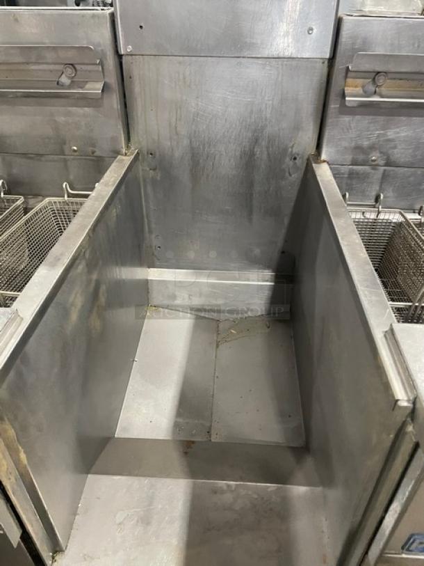 Pitco FGSGH50 commercial stainless steel 4-bay fryer system with center basket hanger, oil filter, and casters, natural gas powered.