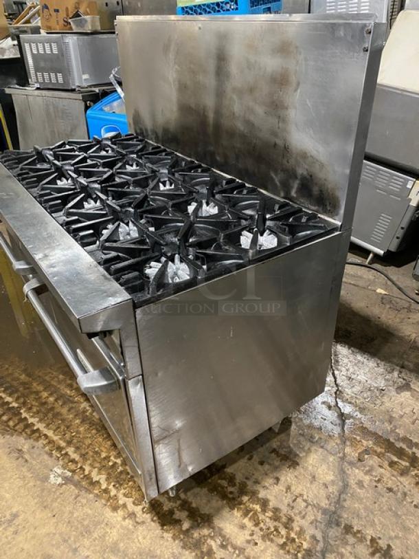 Garland commercial stainless steel 10-burner range and double oven combo, natural gas, with backsplash and wired rack.