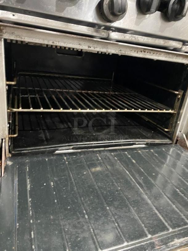 Garland stainless steel 10 burner range with double oven, natural gas, backsplash, wired rack, on legs, commercial use.