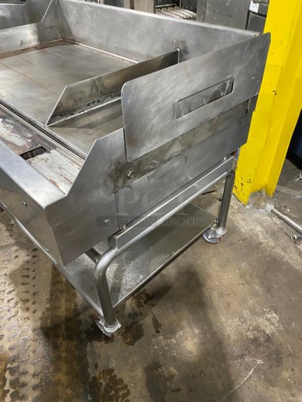 WoodStone stainless steel natural gas countertop plancha griddle with back and side splash, on casters, with undershelf.