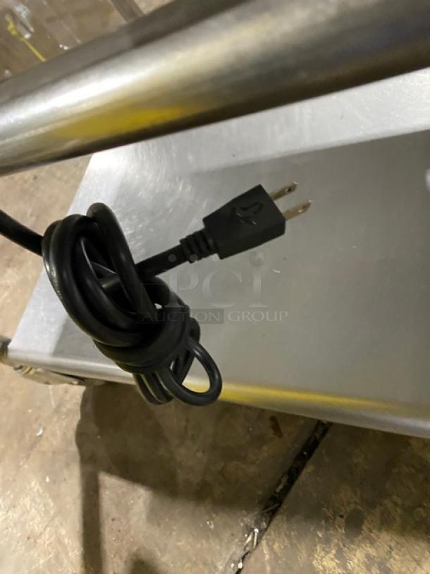 WoodStone stainless steel natural gas plancha griddle, with back/side splash, undershelf cart, SN: GP1B16MAY1704992, on casters.