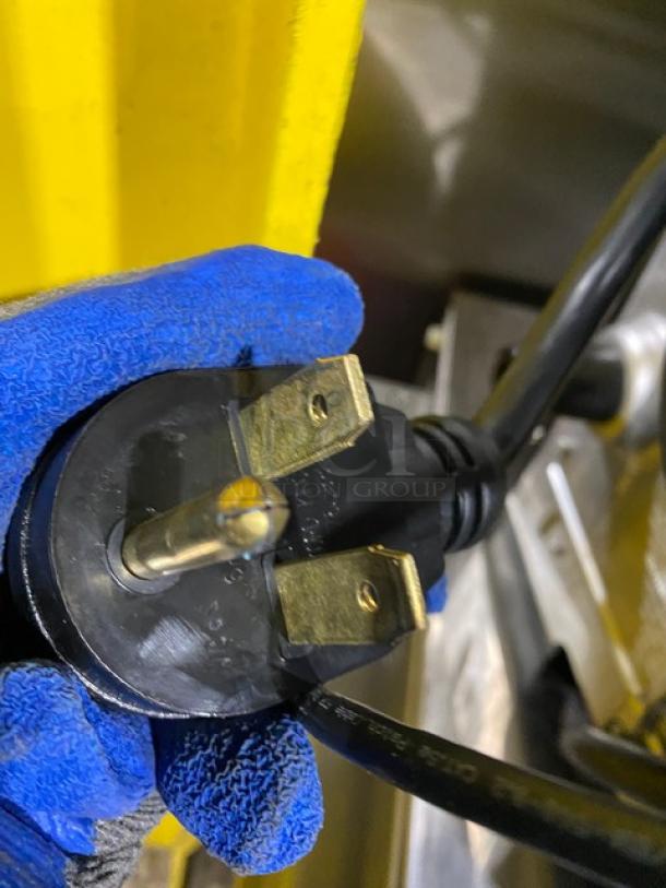 Close-up of a MerryChef Eikon E2S electric plug, highlighting the prongs and black casing; part of a high-speed cook oven.