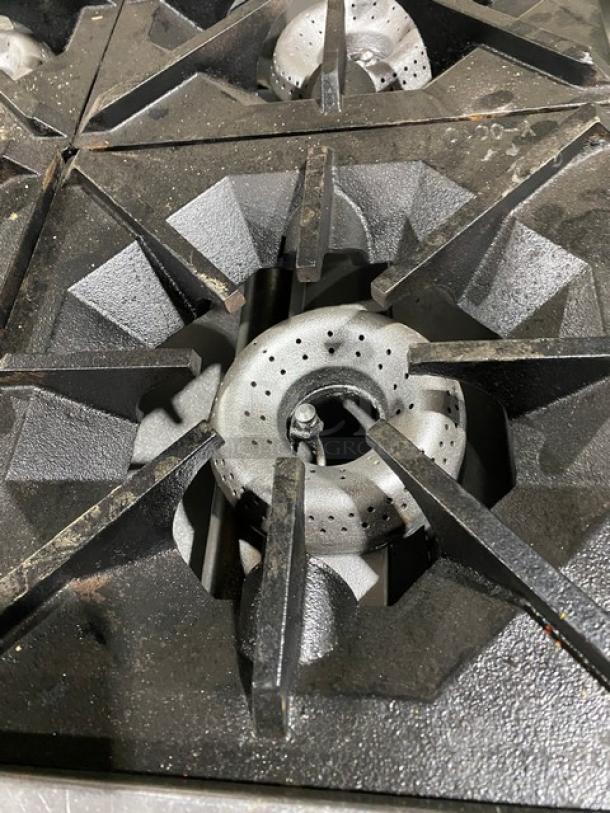 American Range 4-burner commercial stainless steel range with natural gas, featuring clean burners and sturdy cast iron grates.