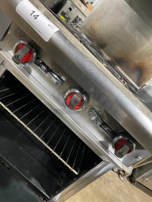 American Range commercial stainless steel 4-burner gas range/oven combo. Features backsplash, salamander shelf, wired oven rack, on casters.