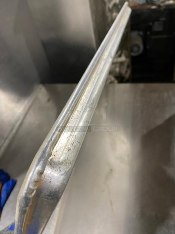 Stainless steel fast food/serving tray, commercial grade, used. Features durable construction with visible wear.