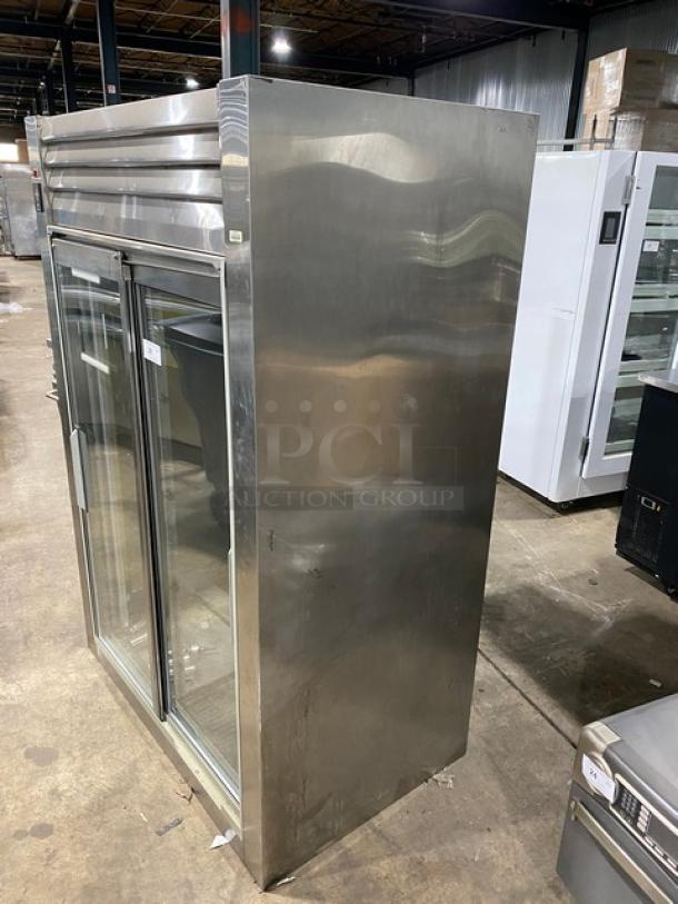 Traulsen RHT232NREFSL commercial refrigerator with double sliding glass doors, wired racks, stainless exterior, on legs. 