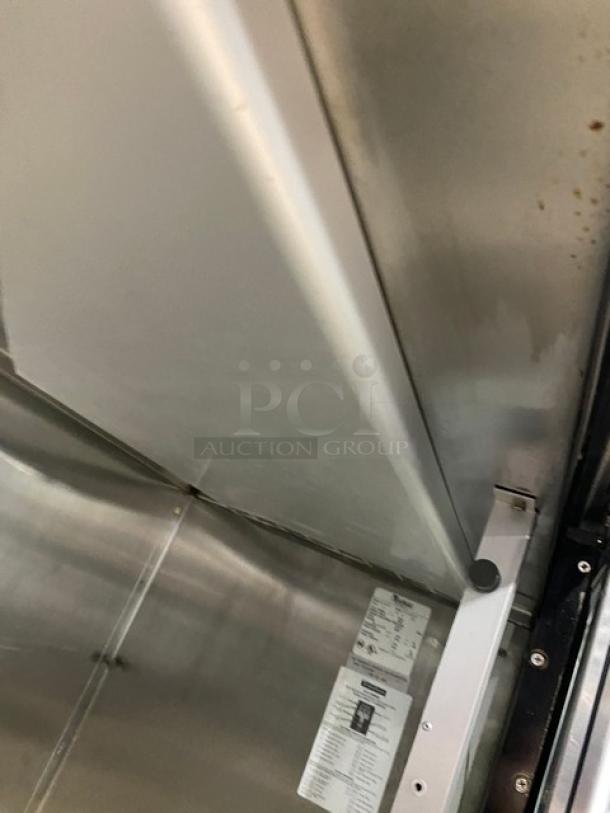 Traulsen RHT232NREFSL commercial double sliding glass door refrigerator interior. Includes wired racks and label visible inside.