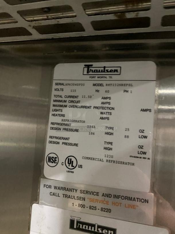 Traulsen RHT232NREFSL commercial double sliding glass door refrigerator with wired racks, model and serial number tags visible.