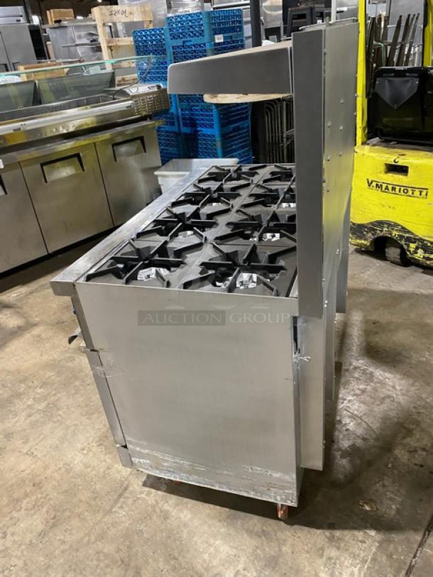 American Range stainless steel 8-burner range with double oven, backsplash, salamander shelf, and casters.