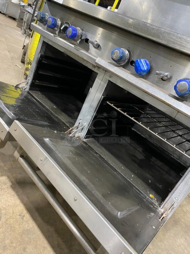 American Range stainless steel 8-burner range with double oven, overhead salamander shelf, and casters. Natural gas powered.