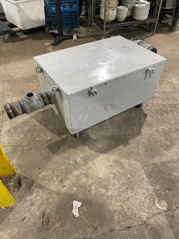 Commercial heavy-duty grease trap/interceptor with metal casing, visible pipe connections, and secure latches. Used condition.