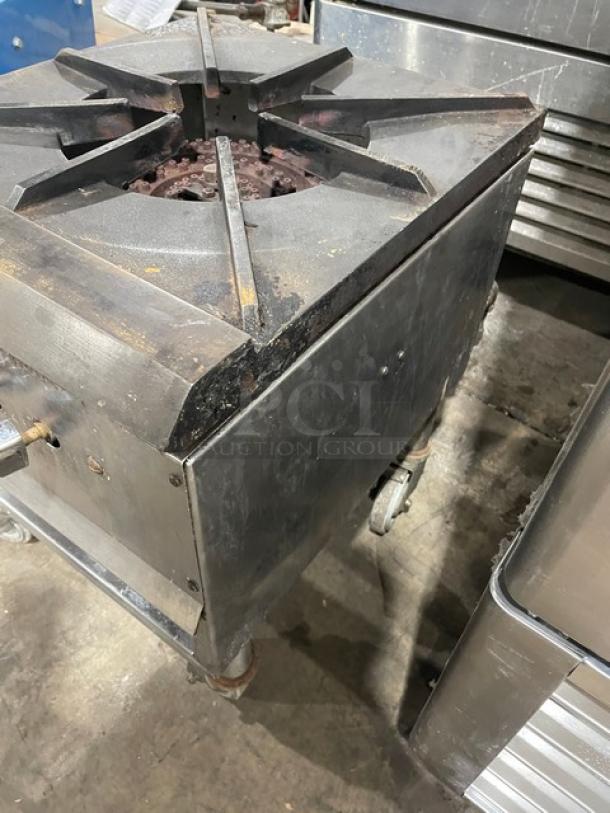 Commercial stainless steel gas-powered single burner stock pot range on casters. Used condition with visible wear.