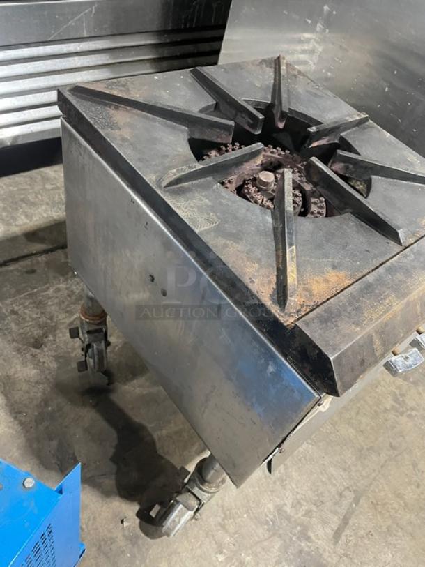 Commercial stainless steel gas-powered single burner stock pot range on casters; features heavy-duty construction, visibly used.