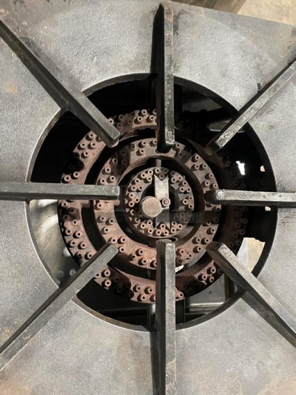 Commercial stainless steel gas-powered single burner stock pot range, features a robust burner, mounted on casters for mobility.