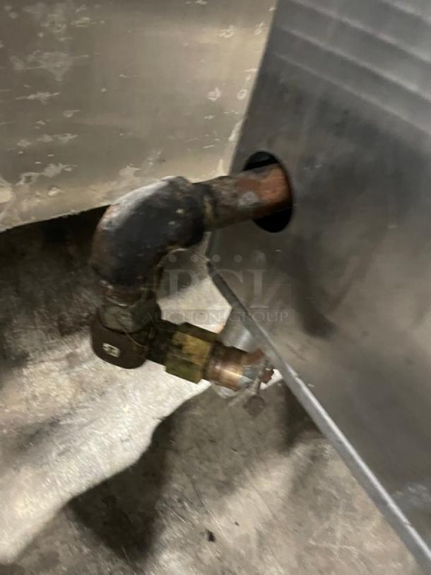 Commercial stainless steel gas-powered single burner stock pot range with visible gas connection. Equipped with casters.